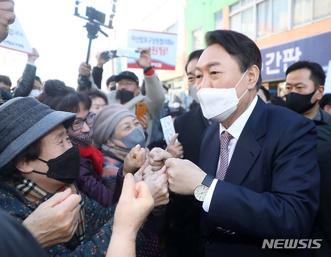 [창원=뉴시스] 김선웅 기자 = 윤석열 국민의힘 대선 후보가 14일 경남 창원시 마산합포구에 위치한 신신예식장을 방문해 무료 예식 봉사로 잘 알려진 백낙삼·최필순 부부와 만남을 마친 후 예식장을 나서며 지지자들과 인사를 나누고 있다. 2022.01.14. mangusta@newsis.com