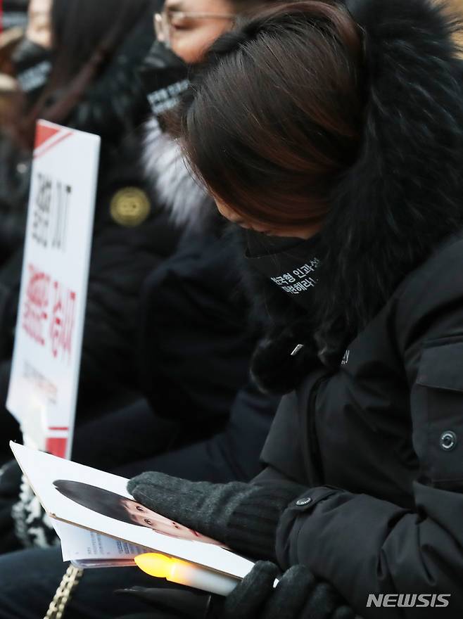[서울=뉴시스] 조수정 기자 = 코로나19 백신피해자가족협의회(코백회) 등 백신 접종후 사망자 유가족들이 15일 오후 서울 청계광장에서 제9회 추모식 및 촛불집회에서 아이의 영정사진을 쓰다듬으며 오열하고 있다. 이들은 정부의 백신 안전성 재검토, 피해보상 전문위원회 심의과정 공개, 백신 피해자 특별법 제정 등을 촉구했다.  2022.01.15. chocrystal@newsis.com