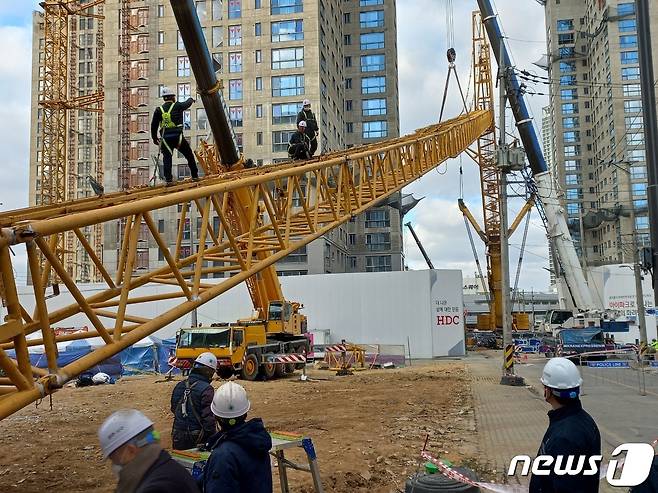 16일 오후 광주 서구 화정동 현대산업개발 신축 아파트 붕괴사고 현장에서 붕괴위험이 있는 타워크레인 해체를 위해 투입할 1200톤급 대형 크레인 조립작업이 한창이다. 소방당국은 조립작업을 거쳐 오는 21일 타워크레인 해체 완료를 목표로 하고 있다. 2022.1.16/뉴스1 © News1 박영래 기자