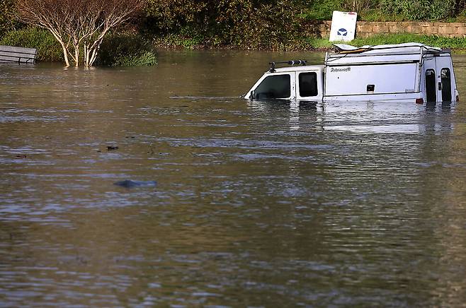 15일 통가 해저화산 분출로 해수면이 높아지면서 미 서부 해안 캘리포니아주 산타 크루즈 해안에 주차돼 있던 트럭이 물에 잠겼다. 산타크루즈/AP 연합뉴스’