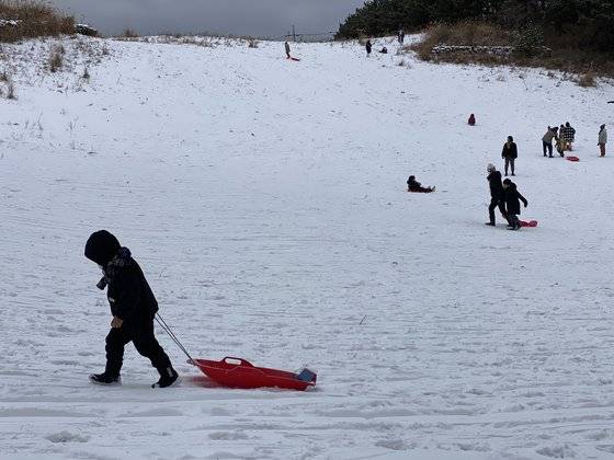 지난 12일 오후 제주 한라산에 내린 폭설로 탐방객들이 눈썰매를 타고 있다. 최충일 기자