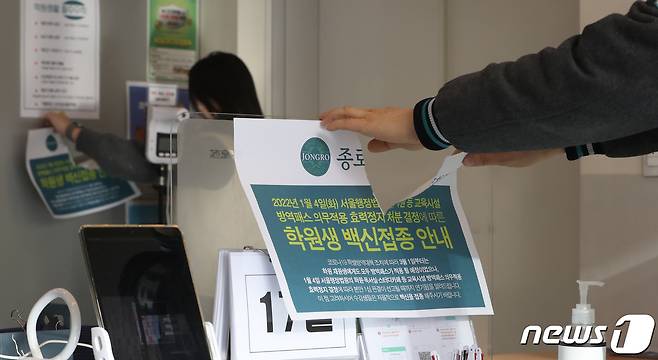 정부가 보습학원·독서실·박물관·영화관·대형마트 등의 방역패스 적용을 해제한다고 밝힌 17일 서울 마포구 종로학원 강북본원에서 관계자들이 방역패스 안내문을 떼고 있다. 2022.1.17/뉴스1 © News1 이성철 기자