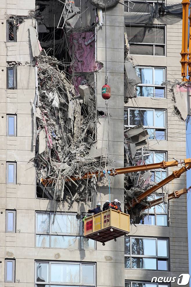 17일 오전 광주 서구 화정동 현대산업개발 아이파크 아파트 신축 공사 붕괴사고 현장에서 소방당국 등 관계자들이 크레인을 타고 사고 현장을 점검하고 있다. 지난 11일 오후 3시46분쯤 해당 공사 현장 201동 건물이 38층부터 23층까지 무너져 작업자 6명이 실종됐다. 실종자 중 1명은 숨진 채 발견됐고 나머지 5명의 생사 여부는 확인되지 않고 있다. 2022.1.17/뉴스1 © News1 황희규 기자
