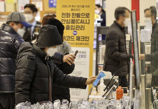 법원의 방역패스 효력 정지 판결 후 첫 주말인 16일 서울의 한 대형마트에서 시민들이 QR코드 체크인을 하고 있다. /연합뉴스