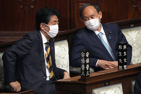 17일 일본 국회에 참석해 대화를 하고 있는 아베 신조(왼쪽), 스가 요시히데 전 총리. [AP=연합뉴스]