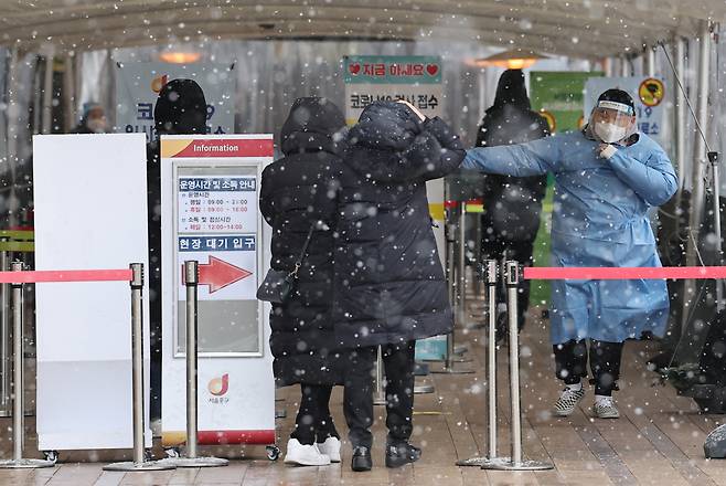 17일 오후 서울 중구 서울시청 앞 코로나19 임시 선별검사소에 눈이 내리고 있다. [연합]
