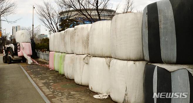 [전주=뉴시스] 김얼 기자 = 17일 전북 전주시 전북도청 앞에서 관계자들이 농민단체가 적재한 곤포 사일리지를 옮기고 있다. 2022.01.17. pmkeul@nwsis.com