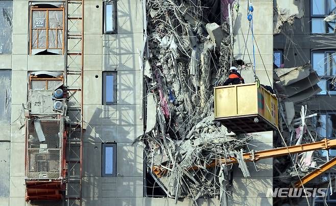 [광주=뉴시스] 류형근 기자 = 광주 서구 화정동 현대아이파크 신축 아파트 붕괴 사고 7일째인 17일 오후 구조안전 자문단들이 크레인을 이용해 붕괴 사고가 발생한 지점을 살펴보고 있다. 2022.01.17. hgryu77@newsis.com