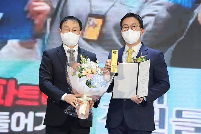 KT 구현모 대표(좌측)와 AI서빙로봇 파트너사 베어로보틱스 김준수 대표(우측)가 ‘파트너 어워드’ 시상 후 기념촬영 하고 있는 모습