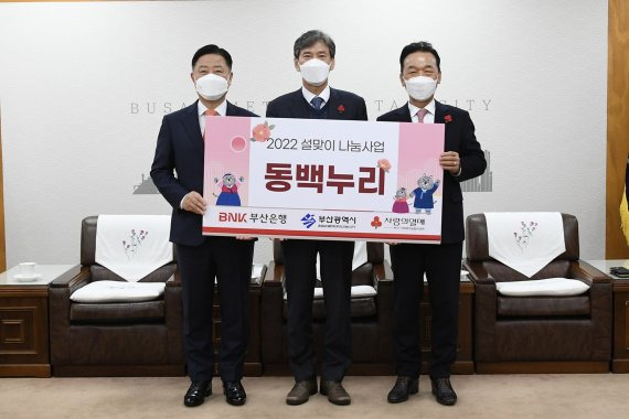 BNK부산은행이 18일 오후 부산시청에서 '설맞이 동백누리 나눔사업'에 동참, 지역 소외계층에게 4억5000만원 상당의 전통시장 온누리상품권을 전달했다. 부산은행 안감찬 은행장(왼쪽), 부산시 이병진 행정부시장(가운데), 부산사회복지공동모금회 최금식 회장이 포즈를 취하고 있다. BNK부산은행 제공