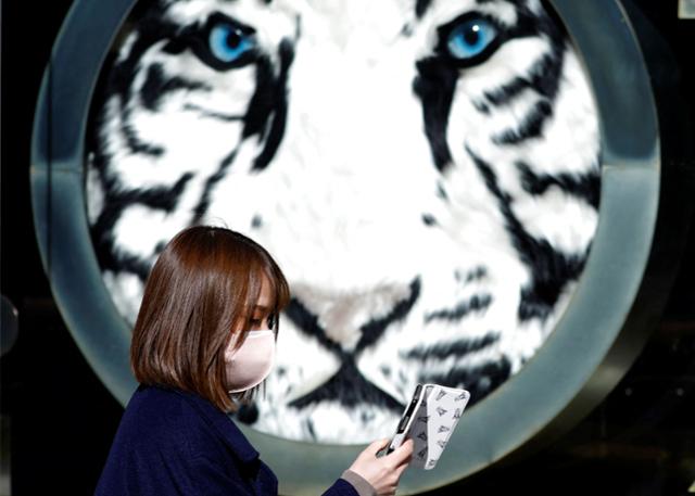일본 전역에서 3만 명 이상, 도쿄에서 5,000명이 넘는 코로나19 확진자가 발생한 18일 도쿄의 한 백화점 앞을 마스크를 쓴 여성이 지나가고 있다. 도쿄=로이터 연합뉴스