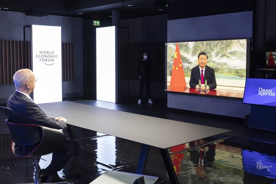 17일(현지시간) 클라우스 슈왑(왼쪽) 세계경제포럼(WEF) 창립자 겸 회장이 이날 열린 ‘다보스 어젠다 2022’에서 시진핑(오른쪽) 중국 국가주석의 화상 연설을 경청하고 있다. [AP=연합뉴스]