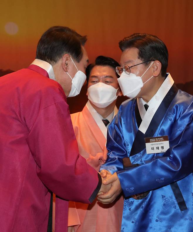 이재명 더불어민주당 대선후보(오른쪽)와 윤석열 국민의힘 대선후보가 17일 서울 중구 프레스센터에서 열린 재경 대구경북인 신년교례회에 참석해 악수하고 있다. 가운데 안철수 국민의당 대선후보. 국회사진기자단