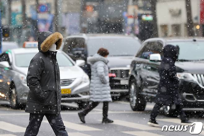 강추위 속 눈이 내리는 17일 오후 서울 종로구 조계사앞 사거리에서 시민들이 눈을 맞으며 걷고 있다. 2022.1.17/뉴스1 © News1 안은나 기자