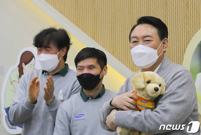 윤석열 국민의힘 대선 후보가 19일 오후 경기도 용인시 처인구 삼성화재 안내견학교를 방문해 장애인 관련 정책공약을 발표한 후 강아지 인형 선물을 받고 있다. 2022.1.19/뉴스1 © News1 국회사진취재단