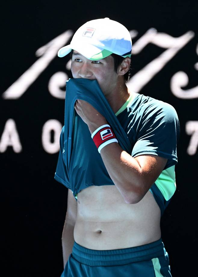 권순우가 19일 호주 멜버른에서 열린 호주오픈 테니스 남자 단식 2회전 데니스 샤포발로프와의 경기에서 유니폼으로 땀을 닦고 있다. 멜버른 | 로이터연합뉴스