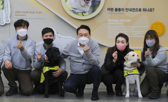 (용인=뉴스1) 국회사진취재단 = 윤석열 국민의힘 대선 후보가 19일 오후 경기도 용인시 처인구 삼성화재 안내견학교를 방문해 장애인 관련 정책공약을 발표한 후 훈련사들과 기념촬영을 하고 있다. 2022.1.19/뉴스1