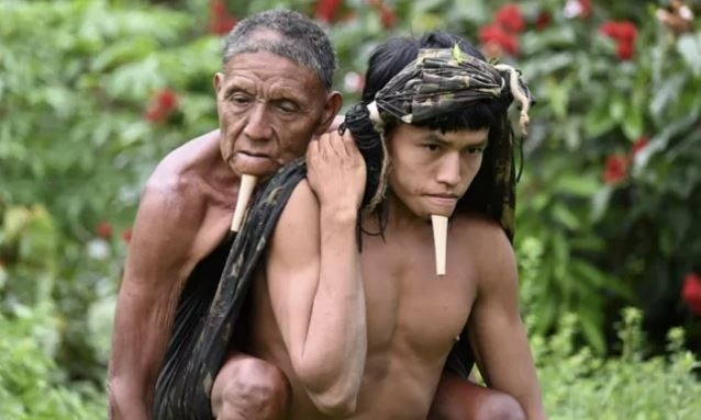 브라질 아마존 원주민인 ‘조예족’ 타위(오른쪽)가 아버지 와후를 업고 아마존 밀림에 설치된 임시 코로나 백신접종센터를 향해 걷고 있다. 인스타그램