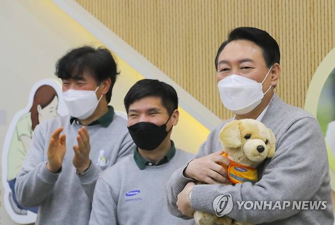 안내견 인형 선물받은 윤석열 대선후보 (용인=연합뉴스) 국민의힘 윤석열 대선후보가 19일 오후 경기도 용인시 처인구 삼성화재 안내견학교를 방문, 안내견 훈련사들로부터 안내견 인형을 선물받고 있다. 2022.1.19 [국회사진기자단] toadboy@yna.co.kr