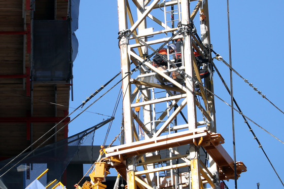 Workers on Thursday dismantle a tower crane that slanted after the collapse of the outer wall of the high-rise Hwajeong I-Park apartment under construction in Gwangju earlier this month. The accident, which took place 10 days ago, killed one person, while search operations for five other missing workers continue. [YONHAP]