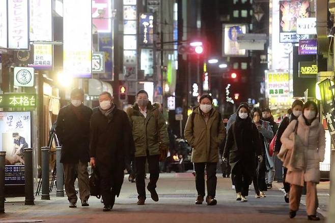 19일 도쿄 시민들이 마스크를 쓴 채 술집과 음식점들이 줄지어 들어선 거리를 따라 걷고 있다. 도쿄 AP=연합뉴스