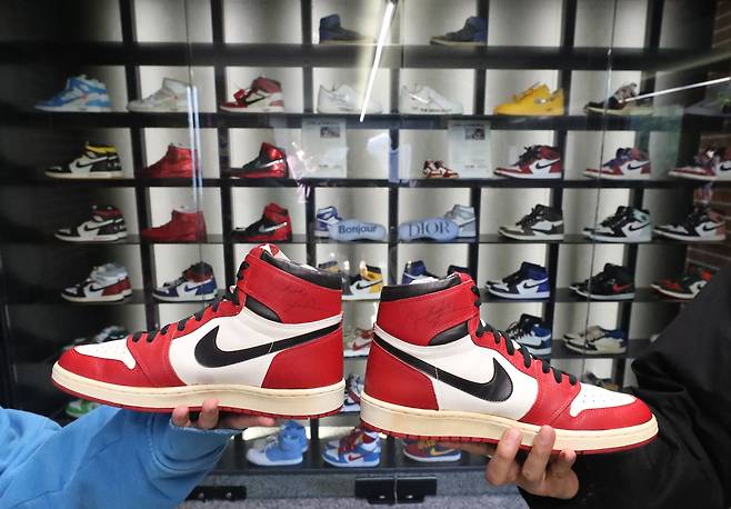 마이클 조던 친필 사인이 적힌 1985년 에어 조던1 시카고의 모습. 신발 뒤로 김주영, 조창호 수집가가 모은 신발들의 모습이 보인다.