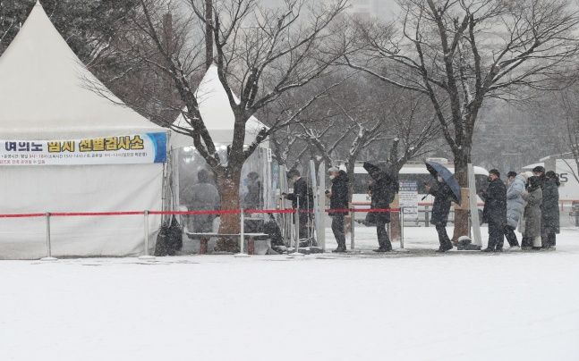 서울 전 지역에 대설주의보가 내려진 지난 19일 서울 여의도 공원에 마련된 영등포구 여의도 임시선별검사소에 시민들이 검사를 받기 위해 줄을 서고 있다. ⓒ데일리안 류영주 기자