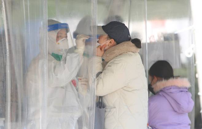 선별검사소의 시민들 대구 중구 국채보상공원에 마련된 임시선별검사소에서 21일 한 시민이 코로나19 검사를 받고 있다. 연합뉴스