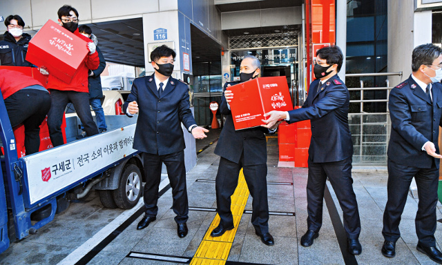 김병윤(오른쪽 세 번째) 서기장관 등 한국구세군 관계자들이 20일 서울 서대문구 홍은종합사회복지관 앞에서 ‘2022 아름다운 설 명절 나눔 키트’를 트럭에 싣고 있다. 신석현 인턴기자