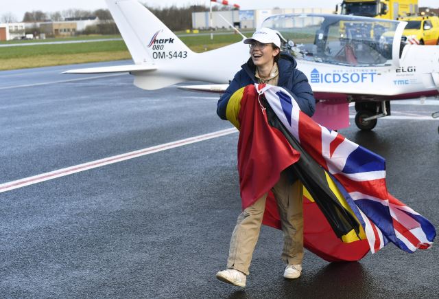 자라 러더포드가 20일(현지시간) 벨기에 코르트리크-베벨겜 공항에 착륙해 영국·벨기에 국기를 몸에 두르고 경비행기에서 걸어 나오고 있다. AP연합뉴스