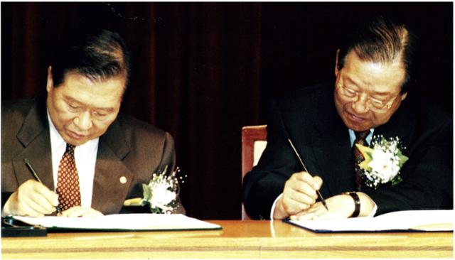 1997년 11월 3일 김대중 국민회의 총재와 김종필 자민련 총재가 국회 의원회관 대회의실에서 양당 후보단일화 합의문에 서명하고 있다. 한국일보 자료사진