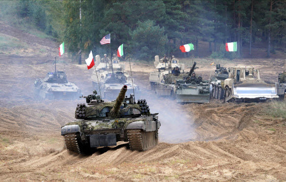 - 우크라이나와 러시아 국경 지대의 군사적 긴장감이 고조되는 가운데 13일(현지시간) 라트비아 카다가의 훈련장에서 열린 나토(북대서양조약기구)의 대규모 군사 훈련 ‘나메즈 2021’에 미국·이탈리아·폴란드 등 군용 차량이 참여하고 있다. 카다가 AP 연합뉴스