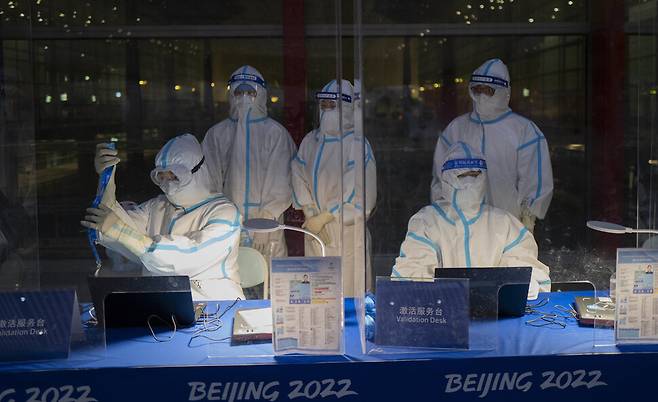 24일 중국 베이징 국제공항에서 베이징겨울올림픽 관계자가 코로나19 감염을 피하기 위해 보호복을 입은채 근무를 하고 있다. 베이징/AP 연합뉴스