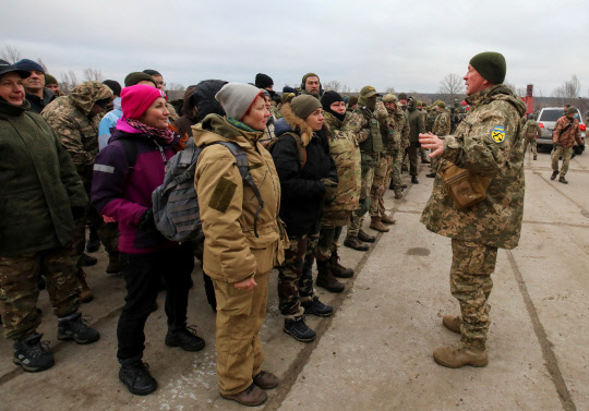 우크라이나 예비군들이 작년 12월 11일(현지시간) 군사 훈련장에서 조교로부터 설명을 듣고 있다. <로이터=연합뉴스>