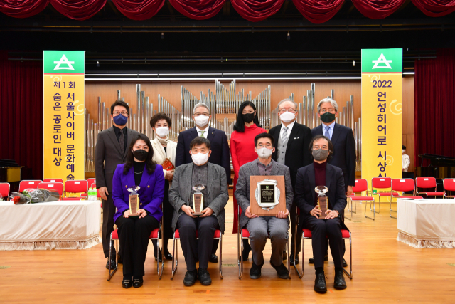 지난 24일 서울사이버대에서 열린 ‘2022 언성히어로 시상식’에서 수상자들이 상패를 들고 기념촬영을 하고 있다. 무대예술센터에서 근무하는 이병섭(아랫줄 왼쪽 세번째)씨가 언성히어로에 선정됐다. /사진=신일재단