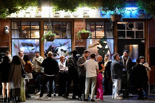 코로나 확산 중 맞는 두 번째 새해 - 12월 31일 영국 런던의 한 술집 주변에 새해를 맞이하러 모인 사람들이 삼삼오오 모여 있다. 2021.12.31. 로이터 연합뉴스