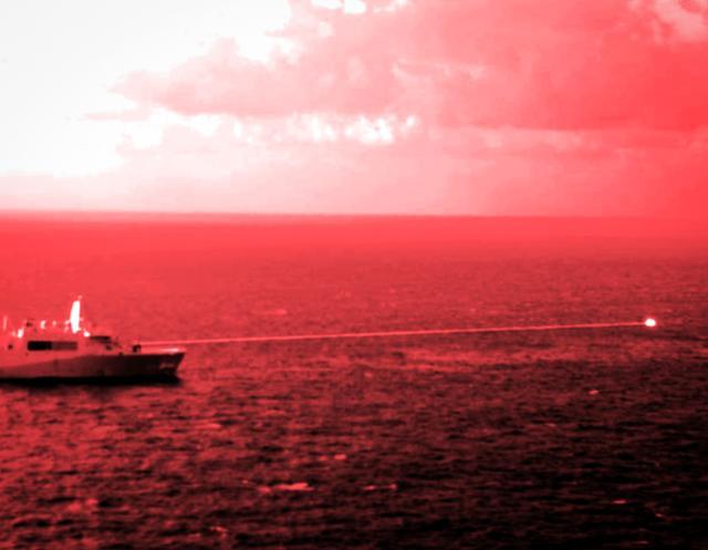 지난해 12월 미 해군 상륙 강습함 USS포틀랜드호가 아덴만 해상에서 레이저 무기를 발사, 목표물을 명중시키고 있다. AP 연합뉴스