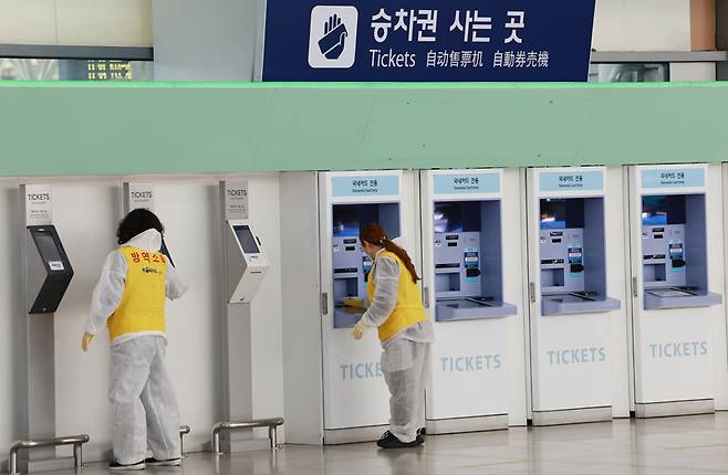 설 명절 연휴를 앞두고 27일 서울역에서 방역 관계자들이 승차권 자동발매기 소독을 하고 있다. / 사진=연합뉴스