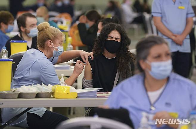 [글래스고=AP/뉴시스] 29일(현지시간) 스코틀랜드 글래스고의 햄든 파크 코로나19 백신 접종소에서 한 여성이 부스터 샷을 맞으며 얼굴을 찌푸리고 있다. 영국은 코로나19 일일 확진자 수가 18만3037명 발생해 전날의 12만9471명보다 약 5만 명이 늘어 역대 최대치를 하루 만에 갈아치웠다. 2021.12.30.