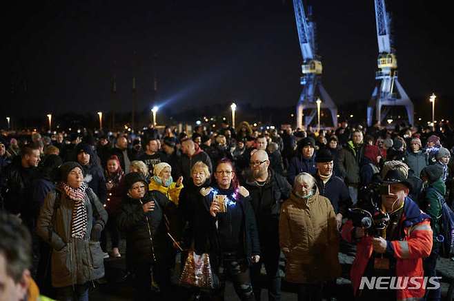 [로스토크=AP/뉴시스] 24일(현지시간) 독일 로스토크에서 정부의 코로나19 방역 조치에 반대하는 사람들이 모여 시위하고 있다. 2022.01.25