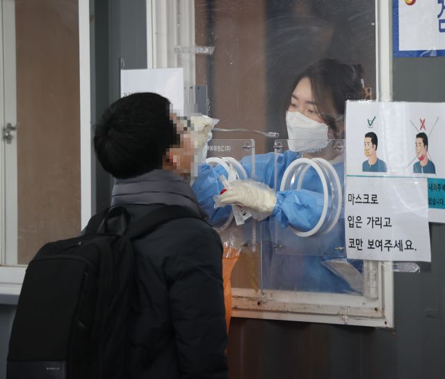 코로나19 신규 확진자가 1만696명을 기록한 28일 오전 서울역 코로나19 선별진료소를 찾은 시민들이 검사를 받고 있다. 연합뉴스