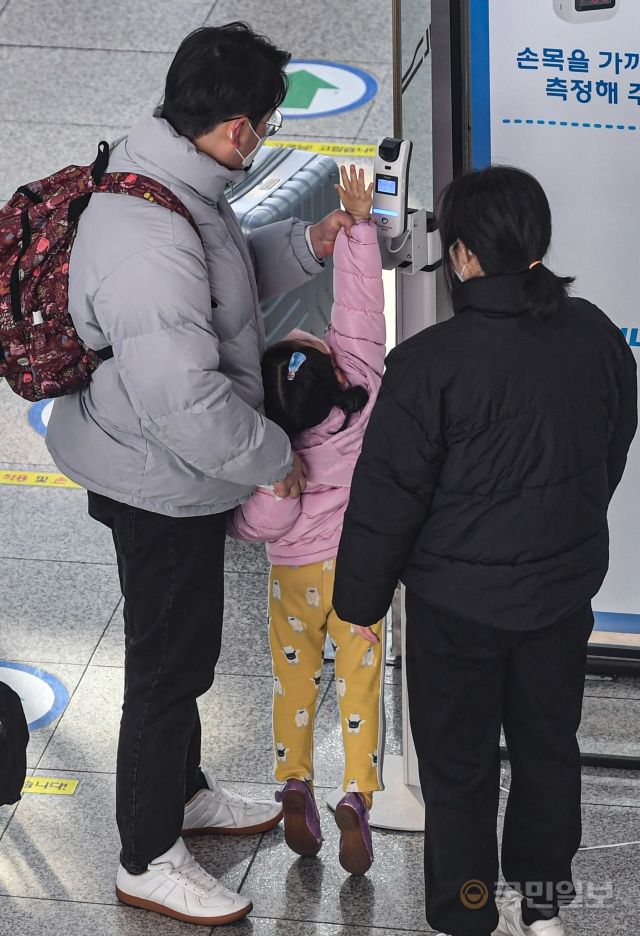 28일 서울역에서 한 가족이 열차 탑승에 앞서 체온을 측정하고 있다.