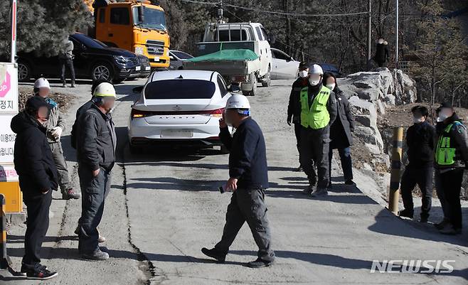 [양주=뉴시스] 조수정 기자 = 29일 경기 양주시 은현면 도하리 삼표산업 양주사업소 석재채취장에서 발생한 토사 붕괴사고 현장에 고용노동부 특별사법경찰관 근로감독관(가운데)가 진입로의 근로자들과 대화나누고 있다. 이날 오전 10시 8분께 골재채취 작업 중 토사가 무너져내리며 작업자 3명이 매몰됐고 그 중 1명이 숨진채 발견돼 3시 6분께 시신을 수습, 병원으로 이송했다. 2022.01.29. chocrystal@newsis.com