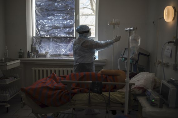 [모스크바=AP/뉴시스] 25일(현지시간) 러시아 남부 크라스노다르주 폴타프스카야 마을의 한 병원에서 의료진이 코로나19 환자를 치료하고 있다. 2022.01.26. /사진=뉴시스