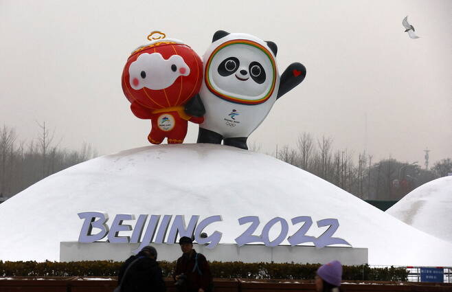 한 마리 새가 2022 베이징겨울올림픽 마스코트인 빙둔둔과 슈롱롱을 형상화한 설치물을 지나가고 있다. 베이징/로이터 연합뉴스