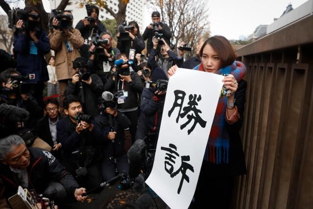 일본 ‘미투 운동’의 상징인 이토 시오리가 2019년 12월18일 일본 도쿄지방재판소에서 ‘승소’라고 적힌 종이를 들고 있다. 도쿄/AP 연합뉴스