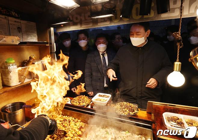 윤석열 국민의힘 대선 후보가 5일 오후 제주 동문시장을 방문해 음식을 사고 있다. 2022.2.5/뉴스1 © News1 구윤성 기자