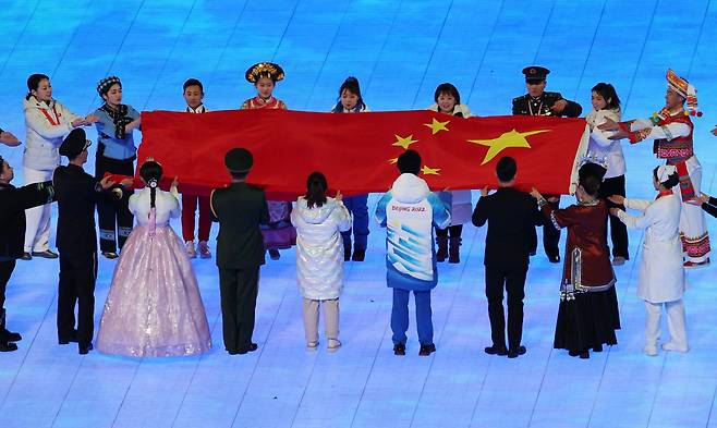 4일 오후 중국 베이징 국립경기장에서 열린 2022 베이징 동계올림픽 개회식에서 한복을 입은 한 공연자가 중국 국기인 오성홍기 입장식에 참여하고 있다. [연합]