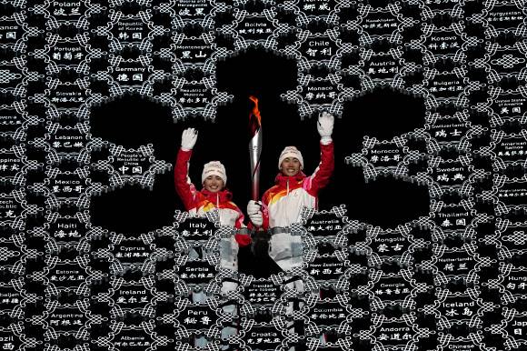 4일 중국 베이징 국가체육장에서 열린 베이징 겨울올림픽 개막식에서 디니거 이라무장(21·왼쪽)과 자오쟈원(21)이 성화를 점화하고 있다. 베이징/타스 연합뉴스