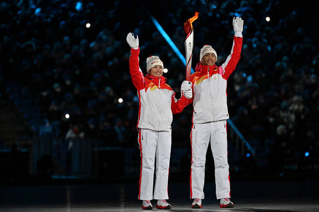 중국 2022베이징올림픽 성화 봉송에 나선 신장 위구르족 출신 크로스컨트리 선수(왼쪽)
